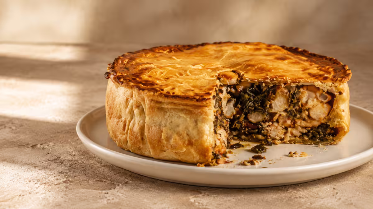 Slice of lampuki pie with dorado fish, spinach and olives