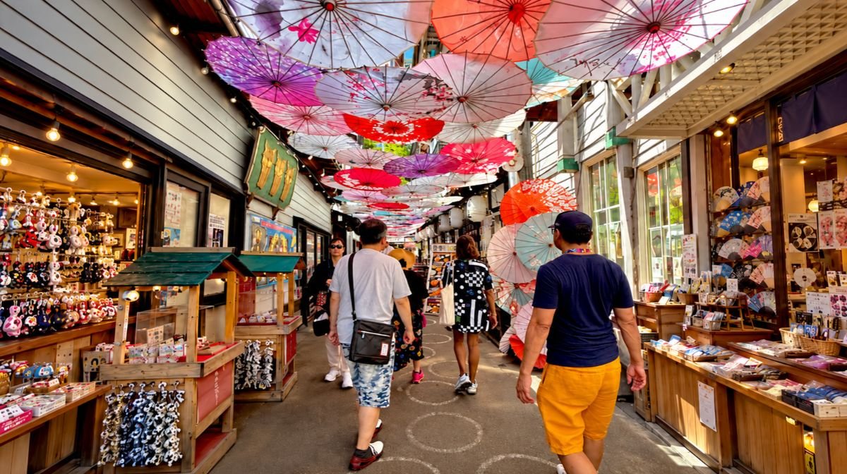 A covered shopping street in Otaru hung with colorful paper parasols