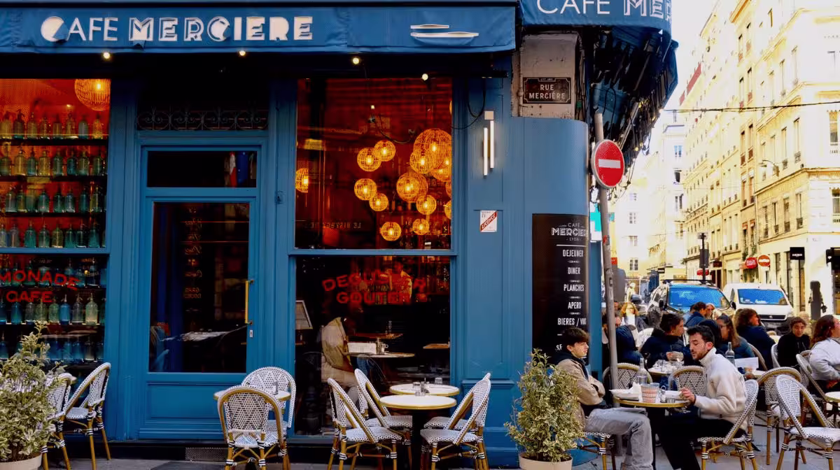 Blue-fronted Café Mercière with outdoor terrace tables on a French street, France travel guide